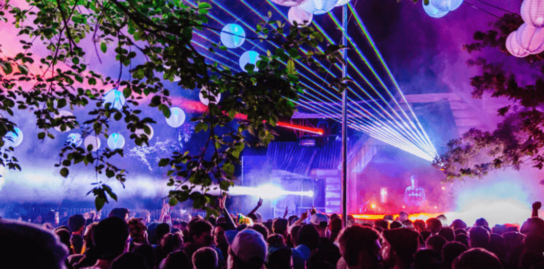 An illuminated stage among the trees at Lost Village